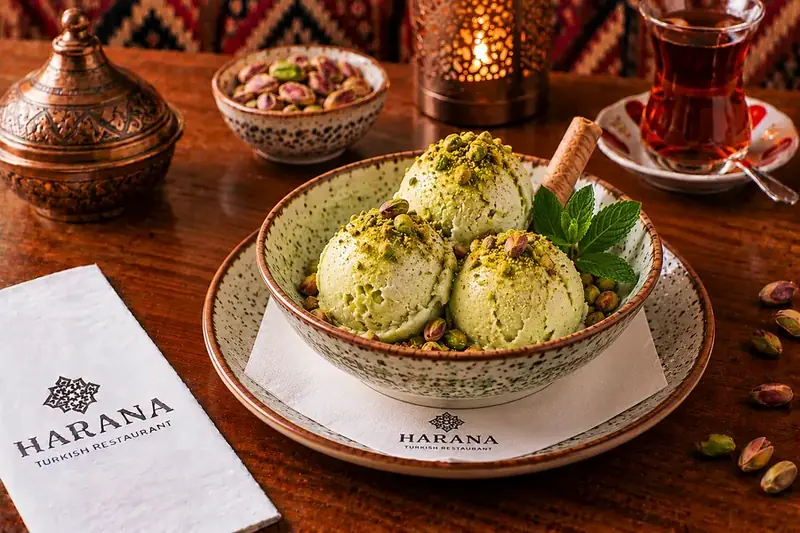 Pistachio ice cream topped with chopped pistachios, served with mint and a wafer roll