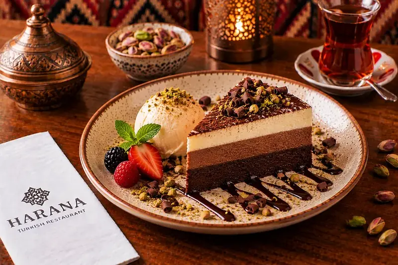 Trio chocolate torte served with vanilla ice cream, pistachios and fresh berries